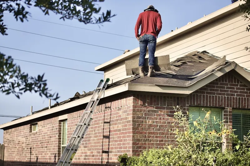 Professional roofer working on a residential roof in Bayway
